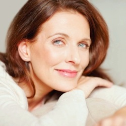 Portrait of a smiling middle aged brunette relaxing on couch